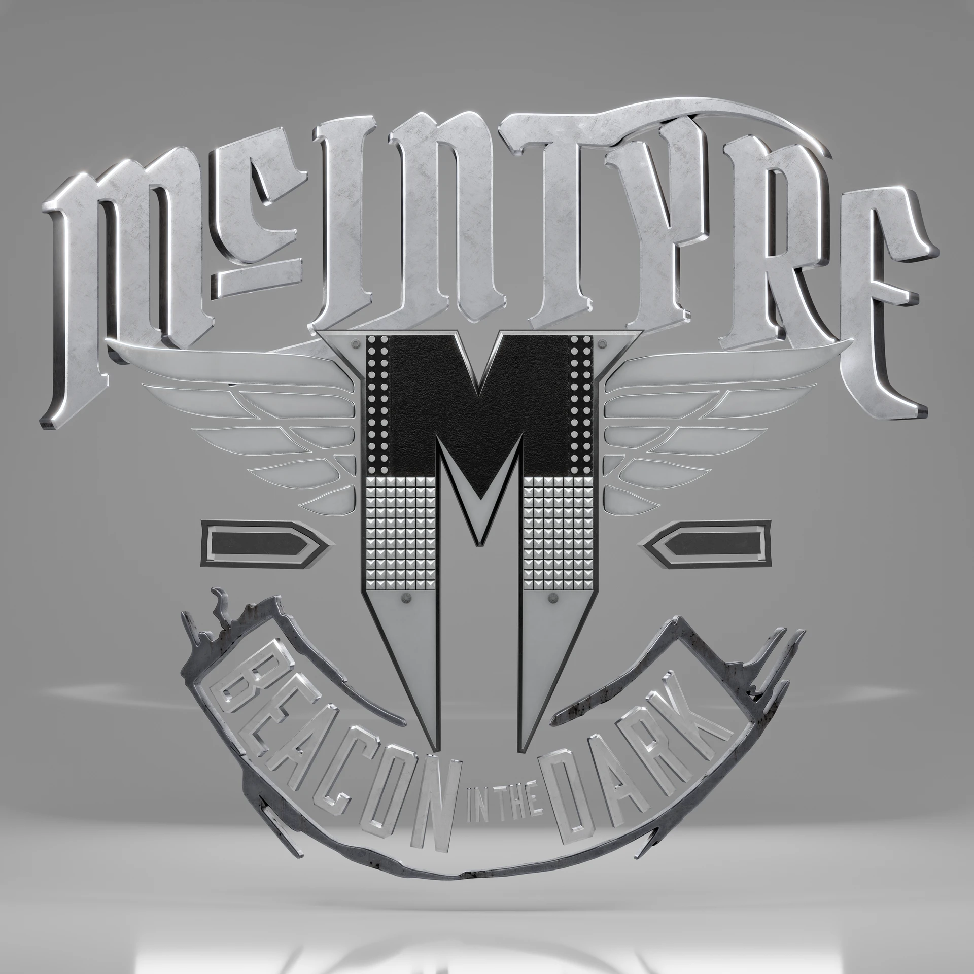 Silver-colored McIntyre emblem with a central M, wing motifs and Beacon in the Dark lettering.